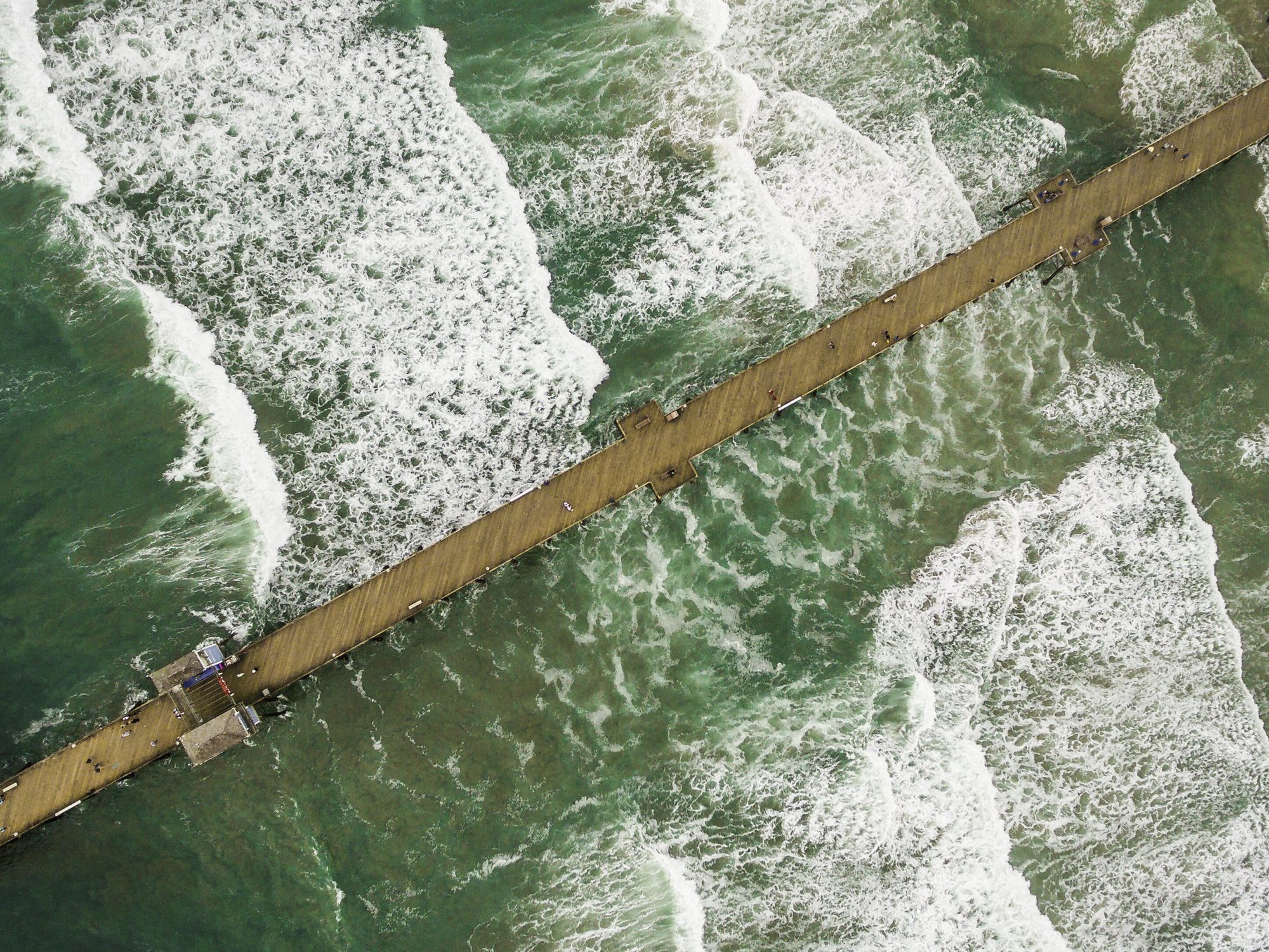 Pilings and concrete bridge structure beneath a Southern California pier